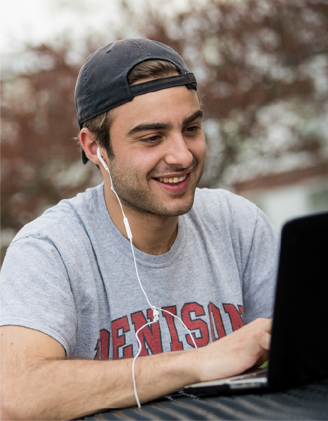 Smiling student working on a laptop